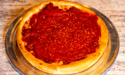 9-inch Chicago-style Deep Dish Grinder pizza with cheese on the bottom, topped with Italian grinder mix and sauce.